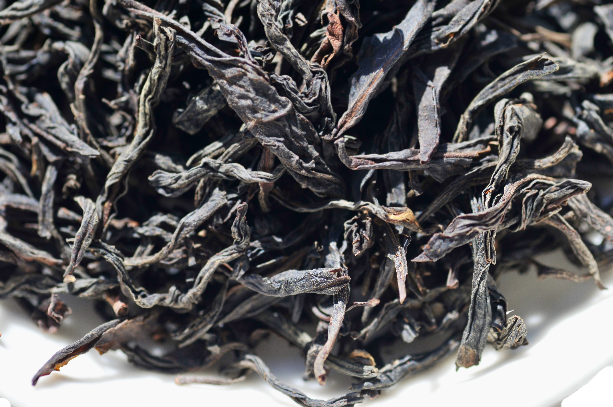 Close-up of dried black tea leaves on a white background